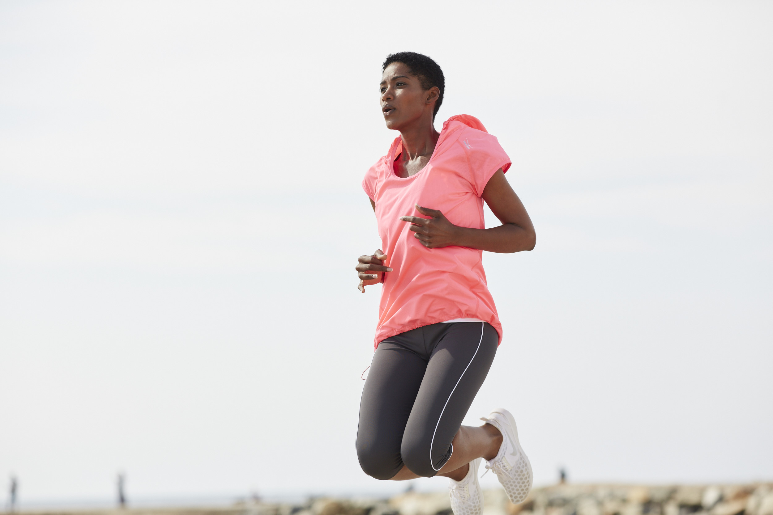 Springende Frau in Sportklamotten