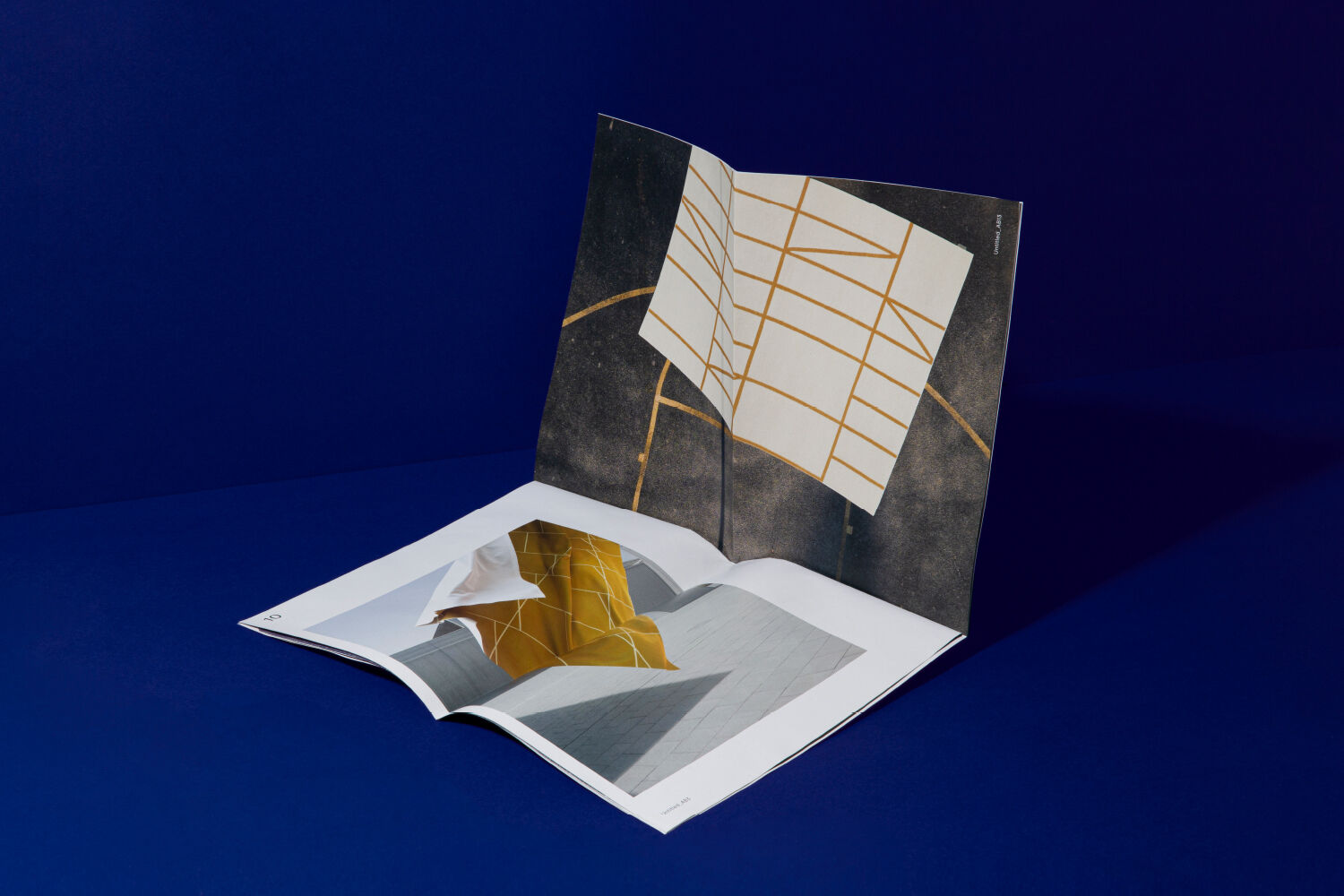 Magazine mockup on blue background. One magazine erected and one magazine lying open.