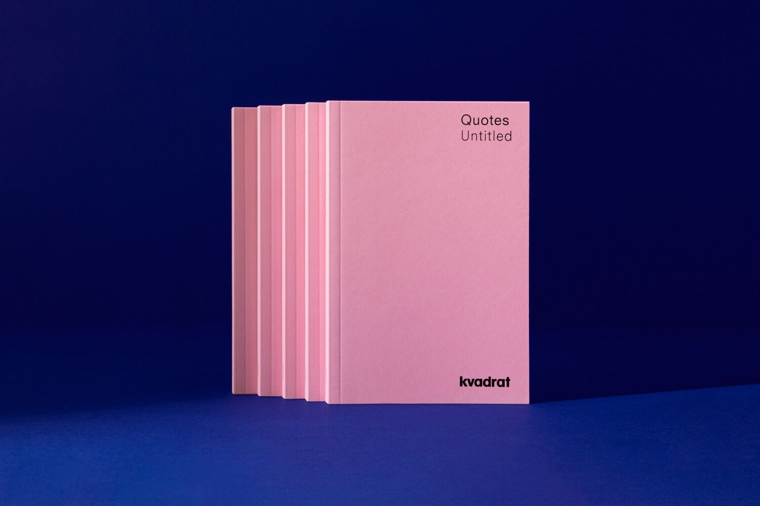 Four pink booklets for Quotes camapgne: placed one behind the other against blue background.