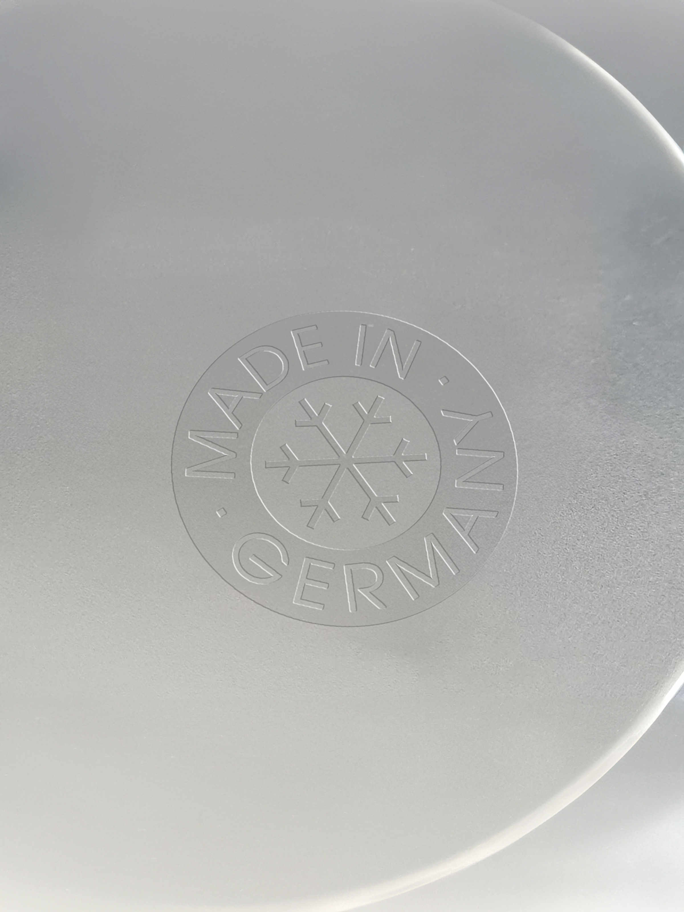 Metal surface with embossed “Made in Germany” seal.